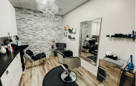 The interior of a suite with a few chairs in the middle and a wall with bricks on it