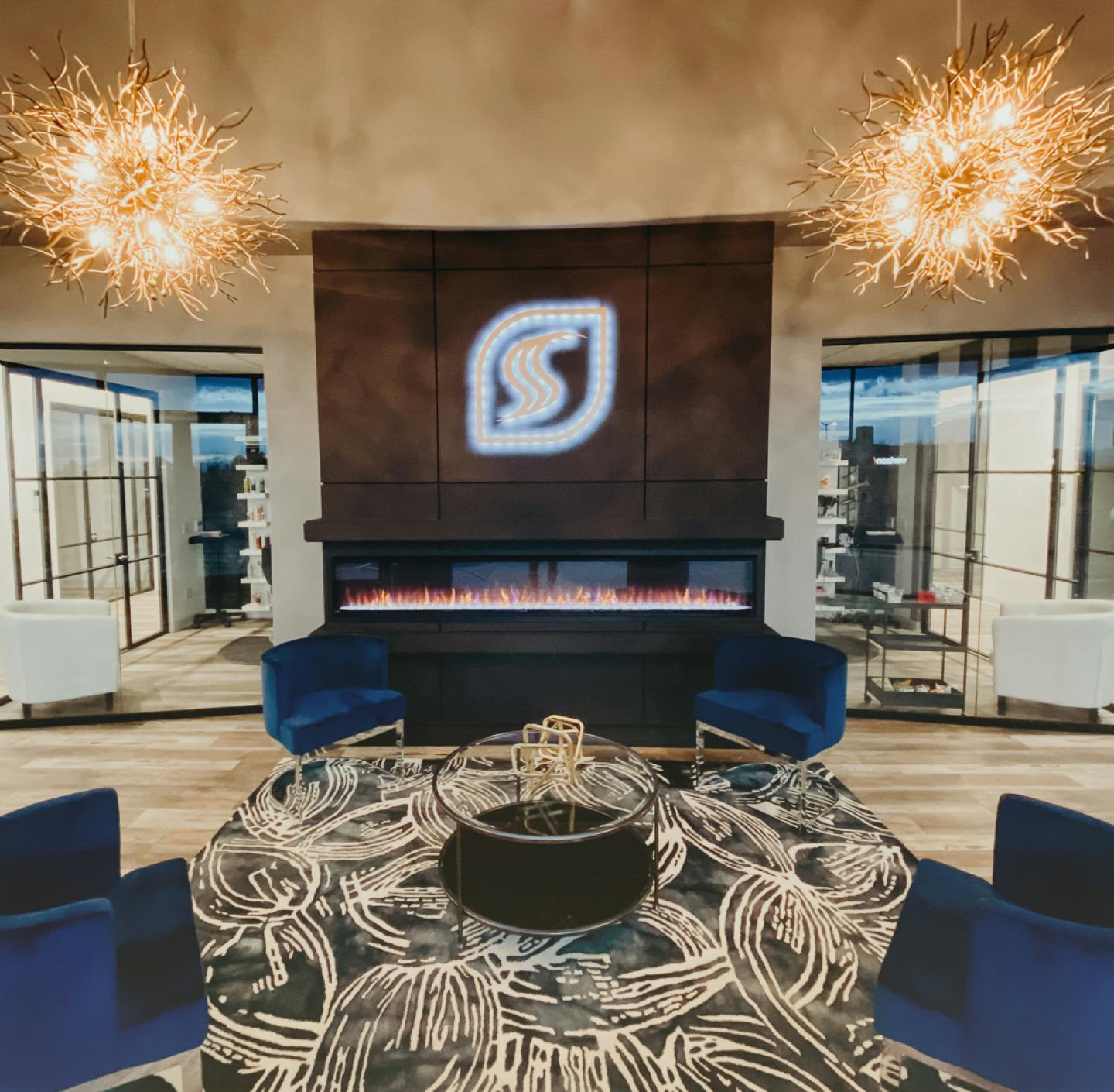 The Spectra Salon suites lobby, with a fireplace and the logo above